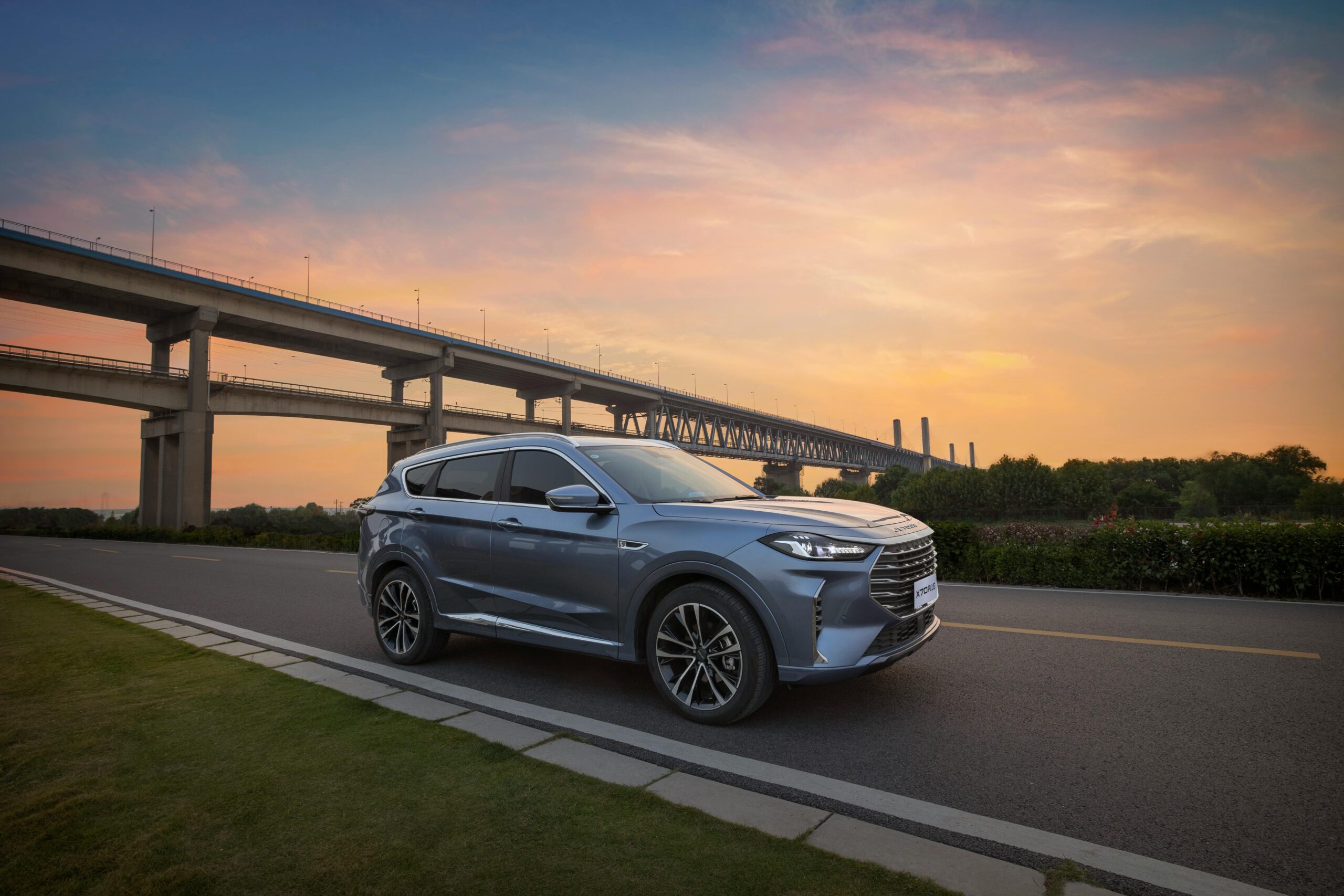 Modern SUV driving on a highway during sunset, showcasing elegance and luxury.